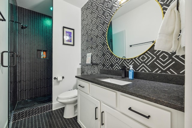 bathroom with toilet, tasteful backsplash, a tile shower, vanity, and tile patterned flooring