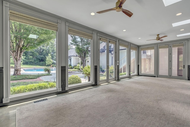 carpeted empty room with a skylight and ceiling fan