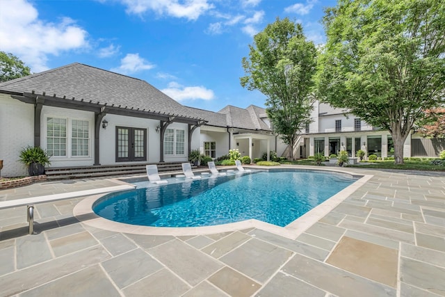 view of pool with french doors and a patio