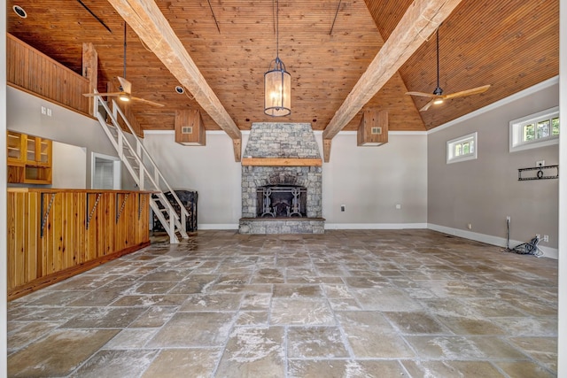 unfurnished living room with wood ceiling, a towering ceiling, a fireplace, and beamed ceiling