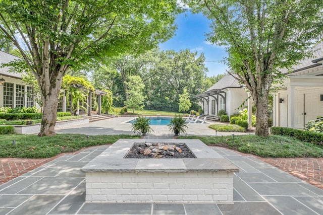 surrounding community featuring a swimming pool, a patio area, and a fire pit