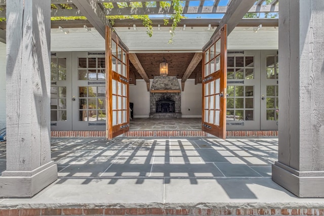 view of patio featuring french doors and an outdoor stone fireplace