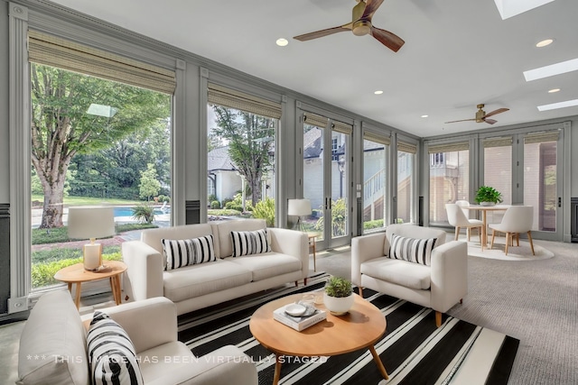 sunroom with a water view, ceiling fan, and a skylight