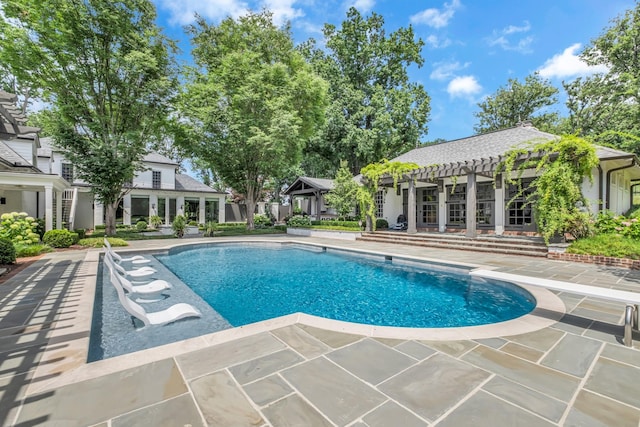 view of swimming pool with a patio, a diving board, an outbuilding, and a pergola