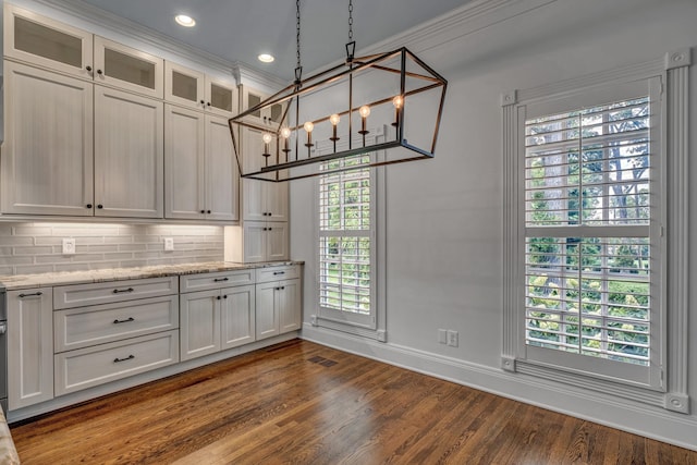 kitchen featuring light stone countertops, white cabinets, and decorative light fixtures