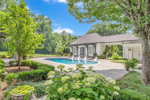 view of swimming pool with french doors, an outdoor structure, and a patio