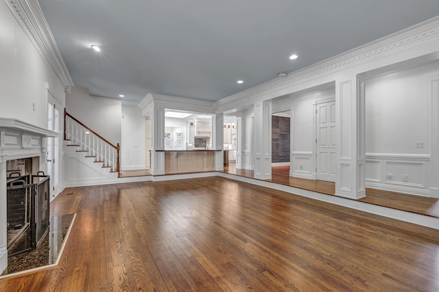 unfurnished living room with crown molding, a premium fireplace, and hardwood / wood-style floors