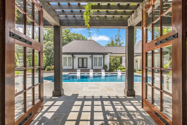 view of swimming pool with an outbuilding, a patio, a pergola, and french doors