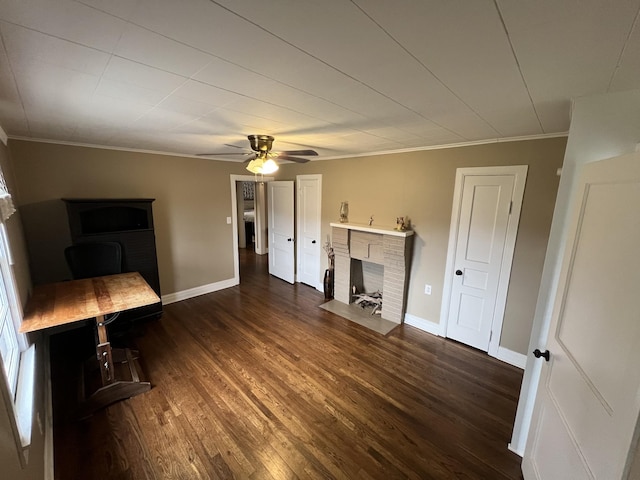 unfurnished living room with dark wood-type flooring, ceiling fan, crown molding, and a brick fireplace