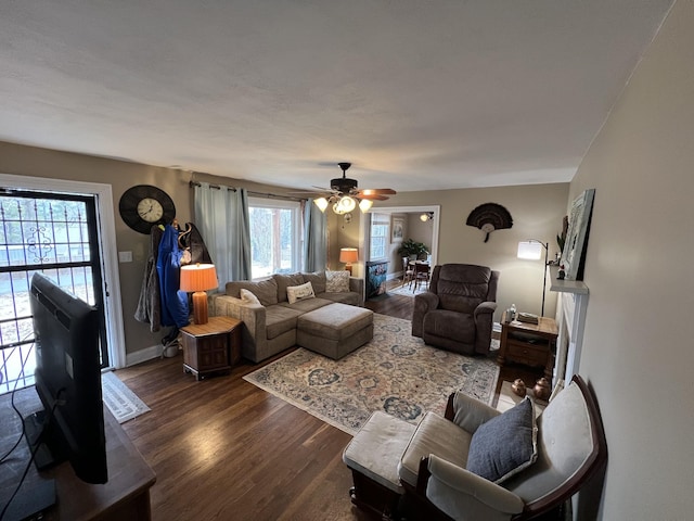 living room featuring ceiling fan and dark hardwood / wood-style floors