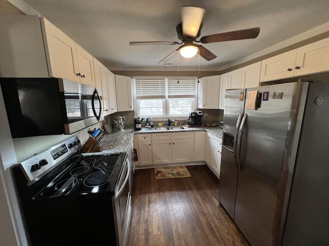 kitchen featuring sink, dark hardwood / wood-style flooring, stainless steel appliances, light stone countertops, and white cabinets