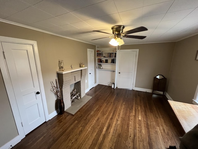 unfurnished living room featuring ornamental molding, a brick fireplace, ceiling fan, and dark hardwood / wood-style flooring