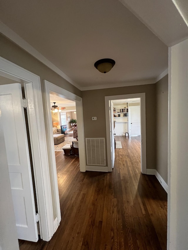 hallway with crown molding and dark hardwood / wood-style floors