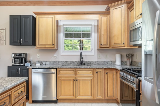 kitchen featuring light stone countertops, appliances with stainless steel finishes, and sink