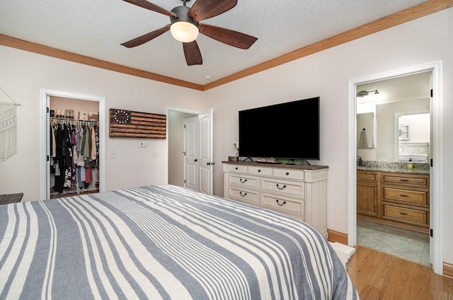 bedroom with crown molding, ensuite bath, light hardwood / wood-style floors, and ceiling fan