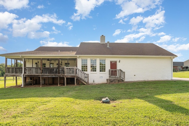 rear view of house with ceiling fan, a yard, and a deck