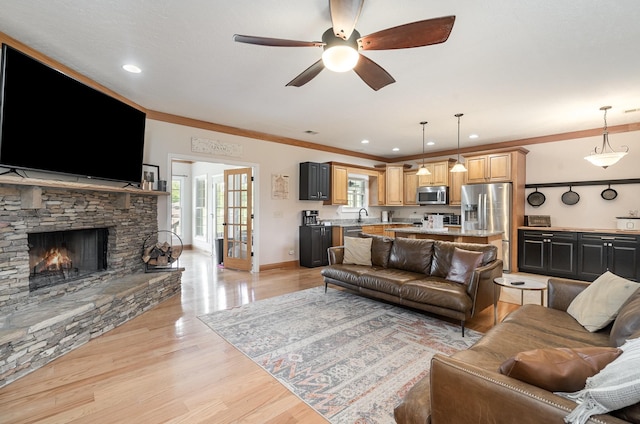 living room featuring light hardwood / wood-style flooring, a wealth of natural light, and ornamental molding