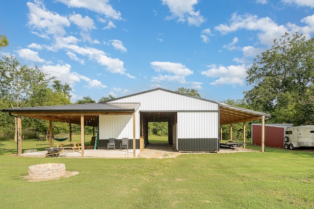 exterior space featuring a yard, an outdoor structure, and an outdoor fire pit