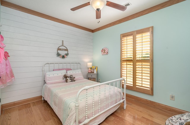 bedroom featuring ceiling fan, ornamental molding, and light hardwood / wood-style floors