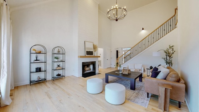 living room with a high ceiling, a notable chandelier, and light hardwood / wood-style flooring