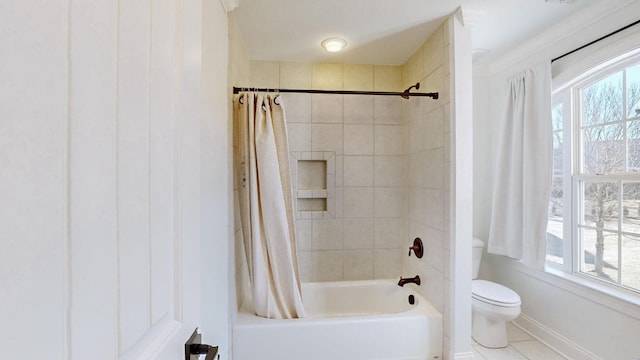 bathroom with tile patterned flooring, toilet, a healthy amount of sunlight, and shower / bath combo with shower curtain