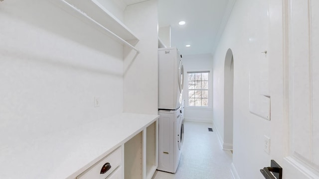 clothes washing area with stacked washer and dryer