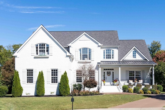 view of front facade with covered porch and a front lawn