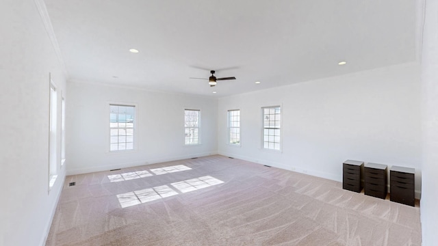 unfurnished room with crown molding, light colored carpet, and ceiling fan