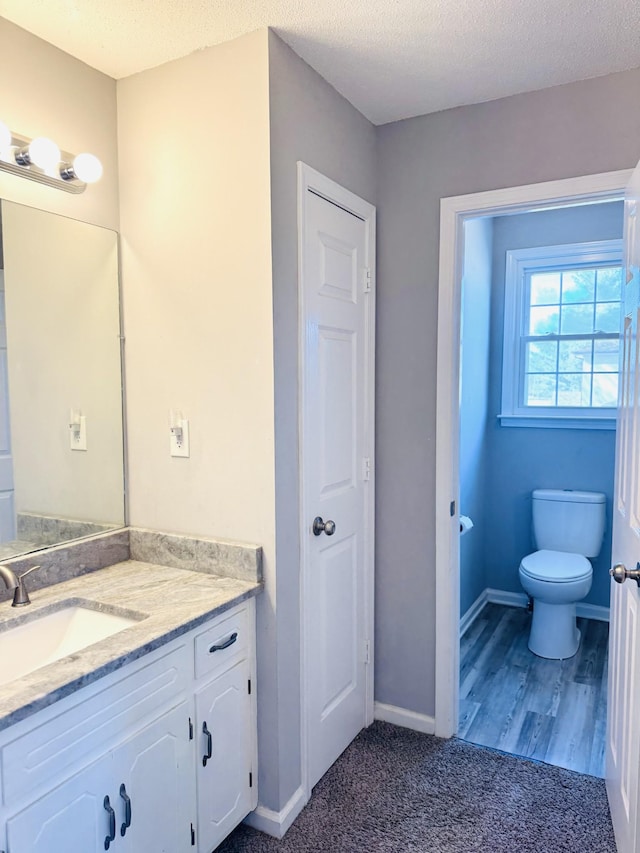 bathroom with vanity, a textured ceiling, and toilet