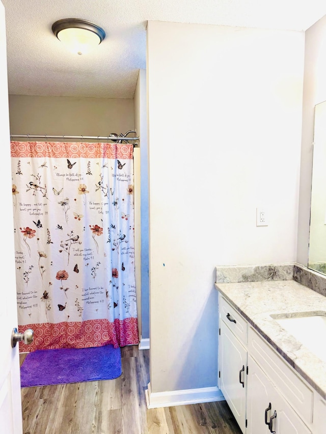 bathroom with vanity, wood-type flooring, and a textured ceiling