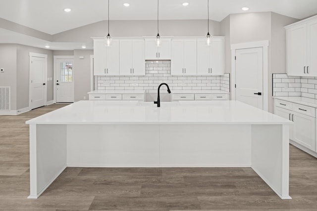 kitchen with a large island, sink, and hanging light fixtures