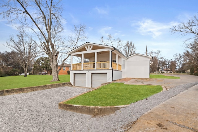 view of front of house with a garage, a front yard, a balcony, and covered porch