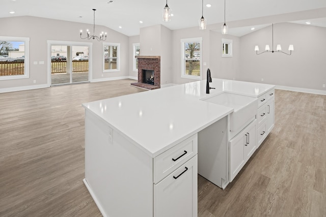 kitchen featuring a healthy amount of sunlight, pendant lighting, sink, and a center island with sink