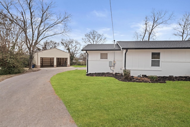 view of property exterior with a garage, an outbuilding, and a lawn