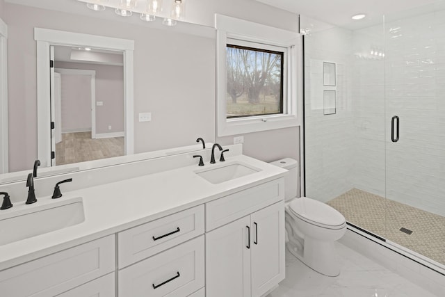 bathroom with vanity, toilet, and a shower with door