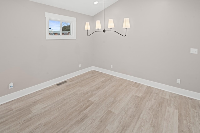 unfurnished dining area featuring light hardwood / wood-style floors and vaulted ceiling