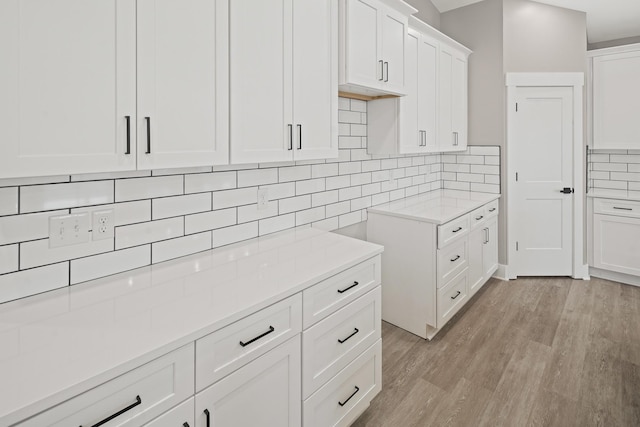 kitchen with decorative backsplash, light hardwood / wood-style floors, and white cabinets