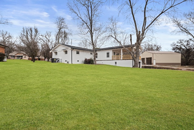 view of yard featuring a garage, an outbuilding, and cooling unit