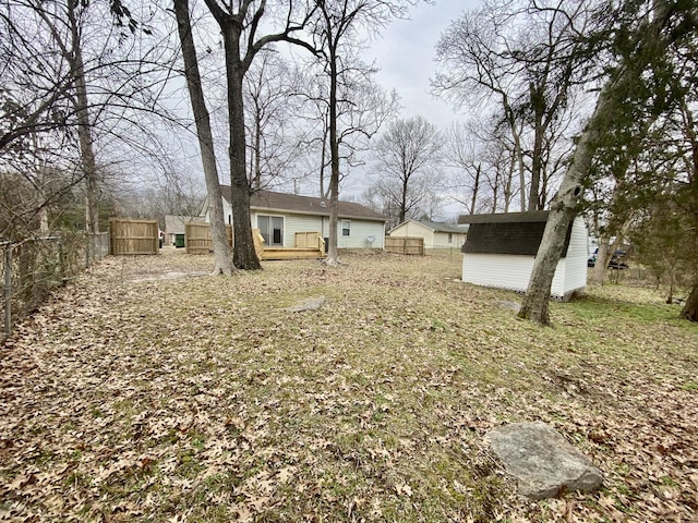 view of yard featuring a wooden deck and a storage unit