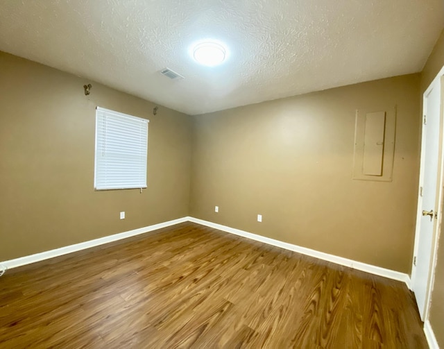 unfurnished room featuring hardwood / wood-style floors and a textured ceiling