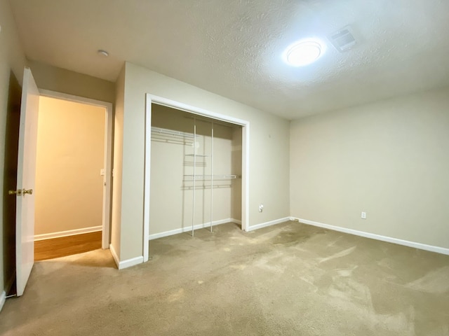 unfurnished bedroom with a closet, a textured ceiling, and carpet