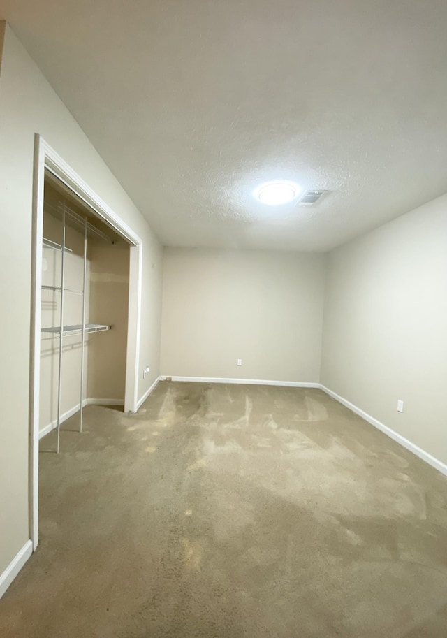 unfurnished bedroom with carpet, a textured ceiling, and a closet