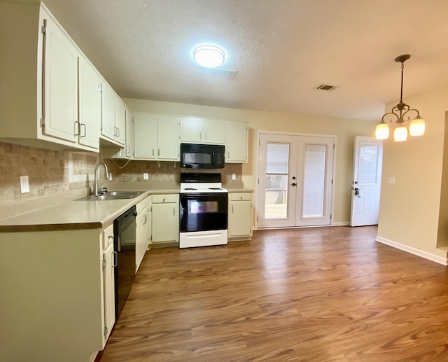 kitchen featuring white cabinets, decorative light fixtures, sink, and black appliances