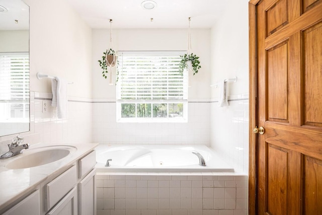 bathroom featuring vanity and tiled bath