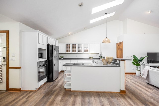 kitchen with decorative light fixtures, a skylight, white cabinetry, dark hardwood / wood-style flooring, and stainless steel appliances