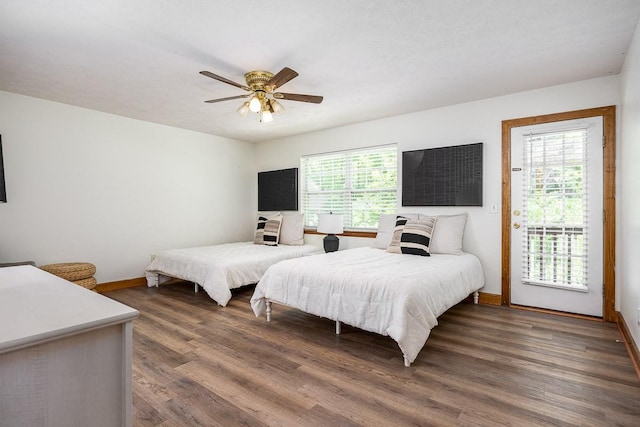 bedroom with ceiling fan, dark hardwood / wood-style flooring, multiple windows, and access to outside