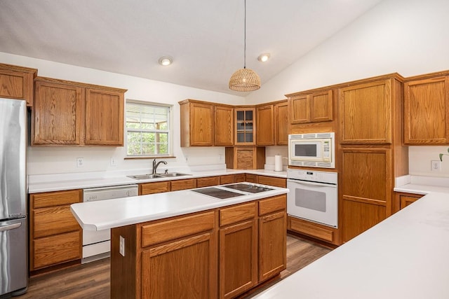 kitchen with pendant lighting, sink, white appliances, lofted ceiling, and dark hardwood / wood-style flooring