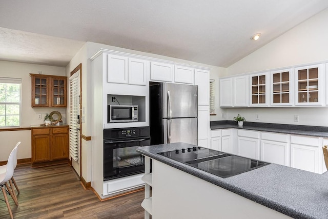 kitchen with white cabinetry, black appliances, dark hardwood / wood-style floors, and lofted ceiling