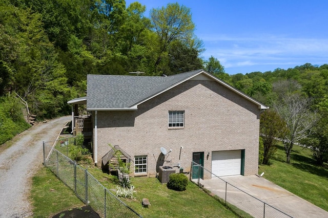 view of home's exterior featuring a yard, a garage, and central air condition unit