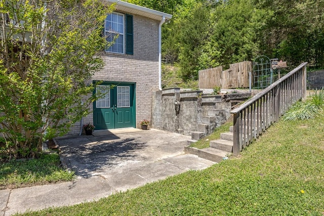 view of exterior entry with a yard